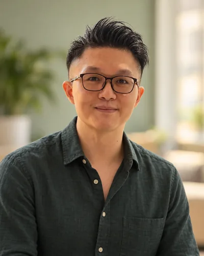 Simon, smiling, in a dark green shirt